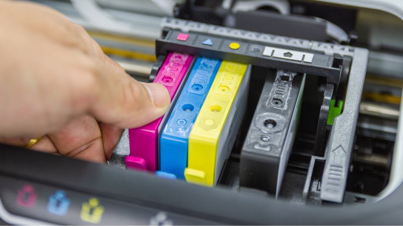 Mano che inserisce cartucce rigenerate all'interno della stampante